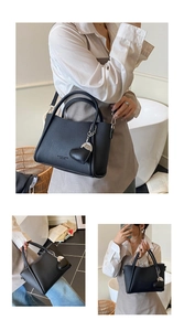 Détail du sac seau en cuir grainé noir avec breloque cœur et bandoulière amovible
