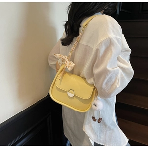 Détail du sac à bandoulière jaune avec foulard en soie à fleurs et breloque peluche