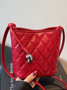 Sac seau matelassé rouge chic avec motif de losanges et pendentif en métal argenté