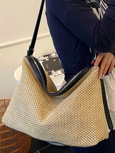 Chic beige woven tote bag with black leather trim and adjustable shoulder strap