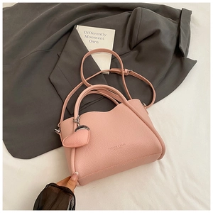 Détails du sac à main rose en cuir litchi avec bords ondulés et logo doré élégant
