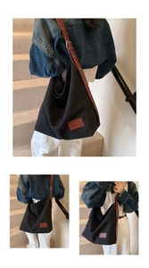 Detail of minimalist black canvas tote with brown leather strap for daily commute