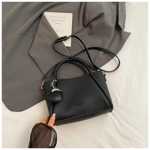 Vue de dessus d'un sac seau noir en cuir grainé avec charme coeur et bandoulière