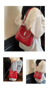 Detail of red crocodile pattern shoulder bag featuring silver chain and metal twist lock