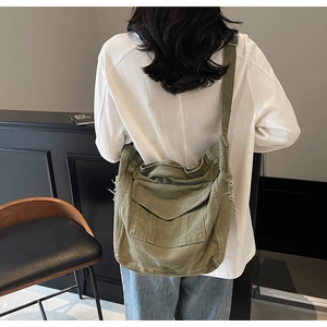 Detail view of army green canvas messenger bag showing vintage frayed edges and flap pocket