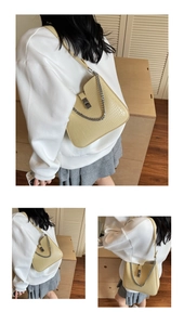 Detail view of cream crocodile embossed underarm bag with silver chain and U-shaped opening