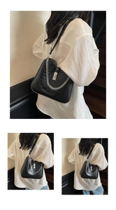 Detail view of black faux crocodile skin shoulder bag with silver chain and metal lock