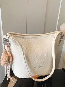 Elegante borsa a secchiello in pelle bianca con ciondolo in peluche e tracolla larga