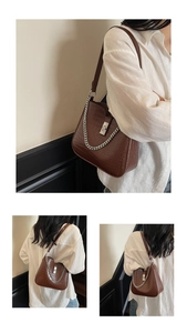 Detail of dark brown crocodile pattern handbag with silver chain and metal buckle