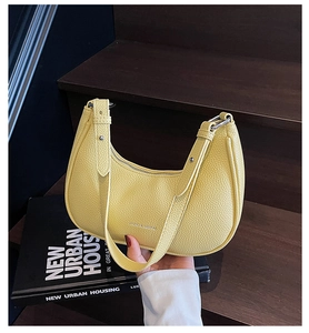 Gros plan du sac demi-lune jaune vif en cuir grainé avec boucle en métal argenté