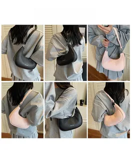 Détail du sac bandoulière demi-lune en cuir motif lychee en couleurs noir et rose