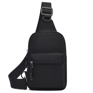 Detail view of black canvas sling bag showing zipper compartments and adjustable nylon strap