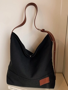 Large black canvas hobo bag with adjustable brown leather shoulder strap for casual wear