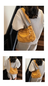 Detail view of mustard yellow canvas crossbody bag featuring multi-layer zipper compartments