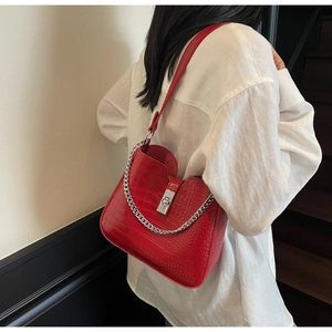 Detail of red crocodile pattern shoulder bag with silver chain and metal square lock