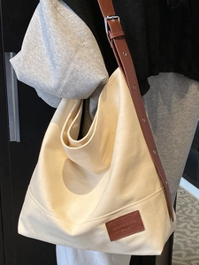 Large cream canvas tote bag with adjustable brown leather straps for daily commute