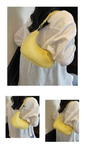 Gros plan d'un sac demi-lune jaune en cuir grainé avec bandoulière réglable chic
