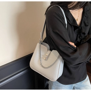 Close-up of light blue crocodile texture leather shoulder bag with silver chain and lock