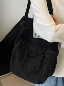 Minimalist large black canvas messenger bag with vintage frayed edges and metal strap buckle