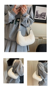 Détail du sac demi-lune blanc en cuir grainé avec fermeture éclair fluide et design élégant
