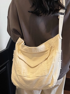 Minimalist beige canvas crossbody bag with wide strap and fringe detail for summer