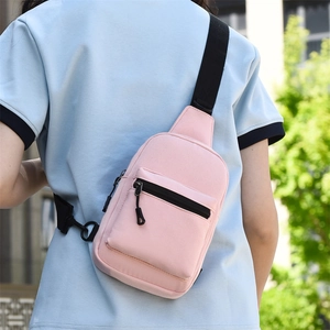 Close-up of a pink crossbody chest bag with adjustable black strap on a person back