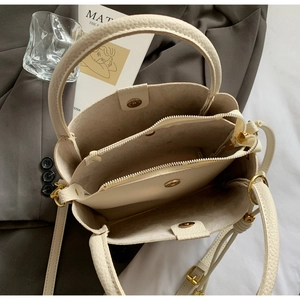 Vue de dessus du sac cabas crème montrant trois compartiments et une boucle magnétique dorée