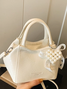 Elegante borsa a secchiello color crema con ciondolo a cuore di perle e fiocco in pizzo