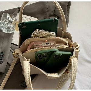 Vue intérieure du sac seau en cuir beige montrant la capacité avec tablette et objets