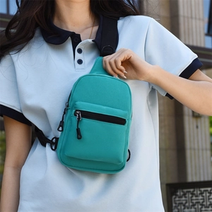 Detail of green canvas crossbody bag with black adjustable strap and front pocket detail