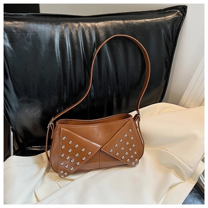 Macro shot of brown faux leather handbag with silver stud details and polished finish