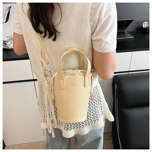 Détail du sac seau beige avec texture litchi et fermeture à cordon en toile