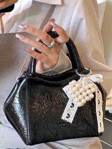 Elegante borsa a secchiello nera in pelle lucida con ciondolo a cuore di perle e nastro