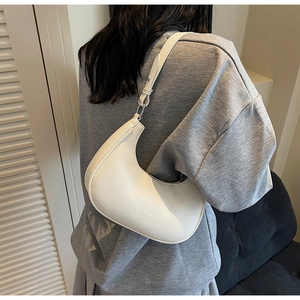 Sac demi-lune blanc en cuir grainé porté par un mannequin pour montrer l'échelle réelle