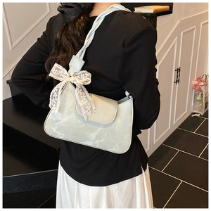 Detail of light blue marble underarm bag with lace bow and woven shoulder strap