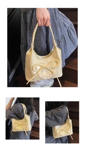 Dettaglio della borsa tote crema con cuori in pizzo e fiocco decorativo morbido