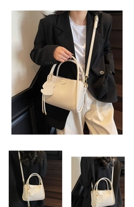 Détails du sac seau en cuir grainé blanc cassé avec pendentif chien et bandoulière amovible