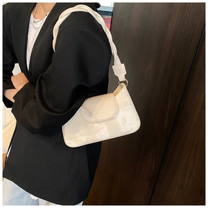 Detail of white marble textured underarm bag with a woven leather strap and gold rings