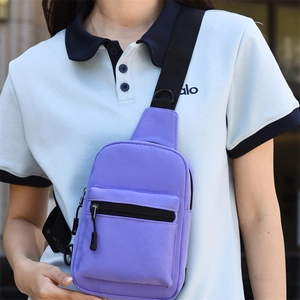 Close-up of a purple canvas sling bag with black adjustable strap and zippers
