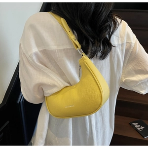 Détail du sac hobo jaune avec texture en cuir grainé et boucle argentée élégante