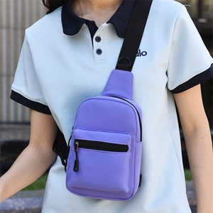 Detail of purple nylon chest bag showing zipper pocket and adjustable strap on a model