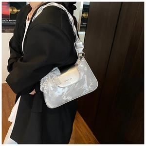Detail of silver metallic shoulder bag with white floral lace ribbon and woven handle