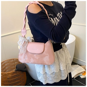 Pink shoulder bag detail with thick woven strap and white lace bow decoration