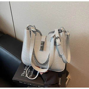 Detail of faux crocodile texture and silver chain on a minimalist tote bag for women