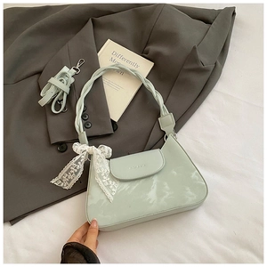 Detailed macro view of the light green underarm bag with lace bow and woven handle