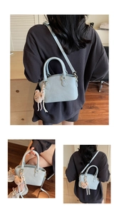 Detail of light blue bucket bag with pebble leather texture and cute plush bear charm
