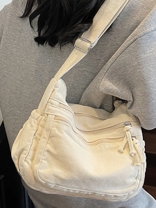 Chic cream canvas crossbody bag with three zip compartments and adjustable wide strap