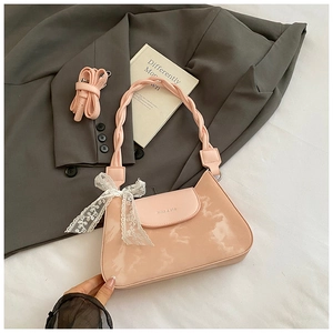 Detail of light pink marble-pattern underarm bag with lace bow and woven handle