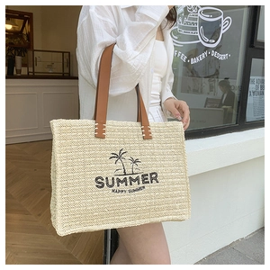 Detail of summer woven tote bag with palm tree embroidery and brown leather handles