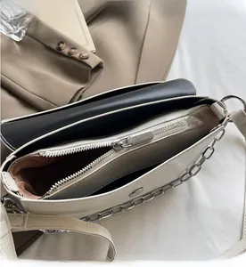 Detail view of cream textured leather bag with smooth silver zipper and interior pockets